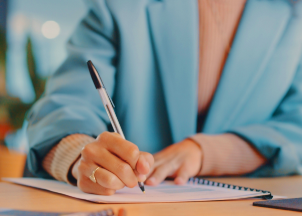 Close up of Lady's hands holding pen and signing document