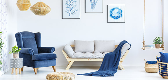blue armchair and white timber couch with blue throw rug